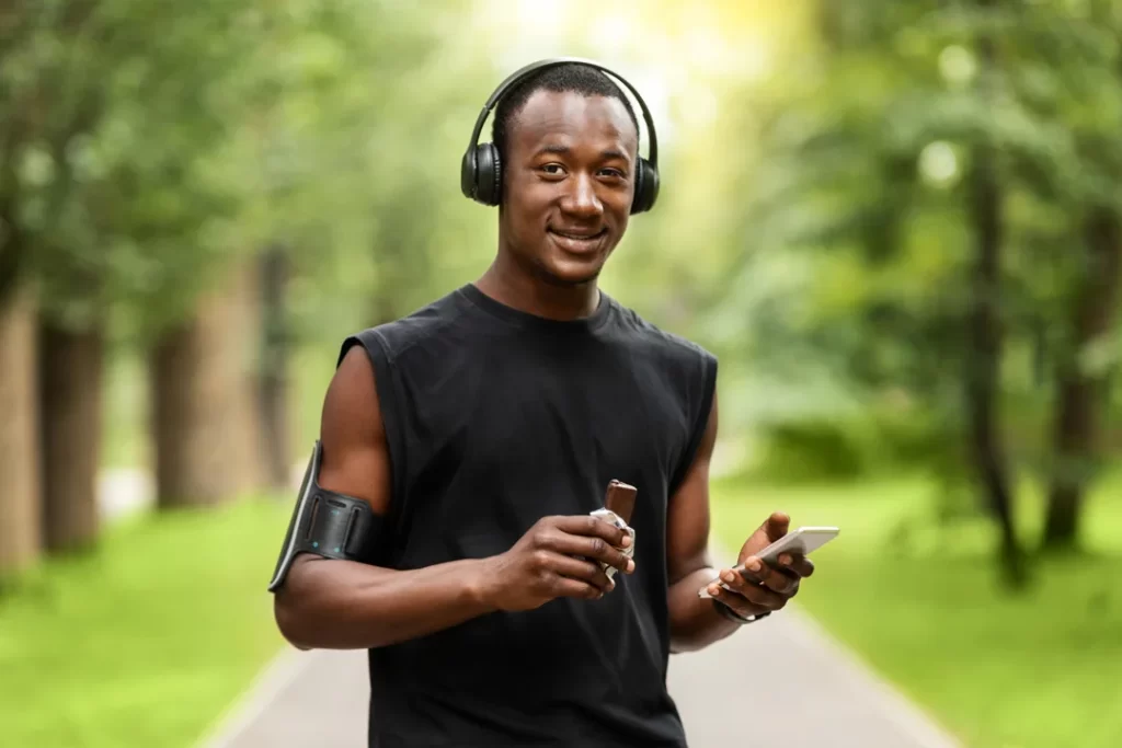 Smiling black guy sportsman eating Gatorade protein bar